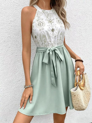 Floral print a-line dress with tie waist and sage green skirt.