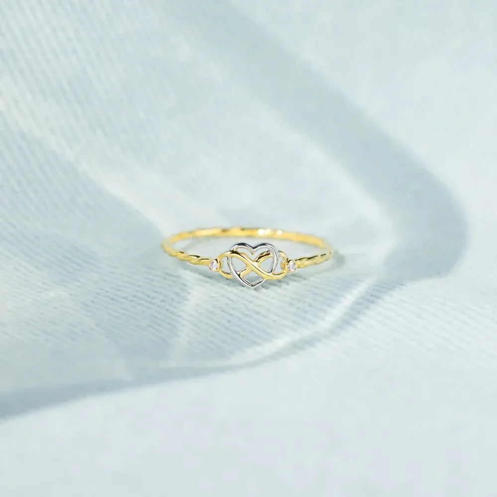 Gold intertwined heart and infinity ring with small accent stones.