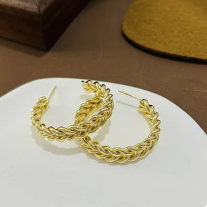 Elegant twisted gold hoop earrings, 18K gold-plated alloy.