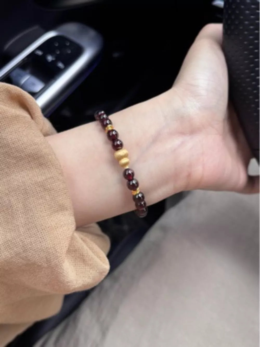 Garnet and gold gourd charm bracelet with red beads and gold accents.