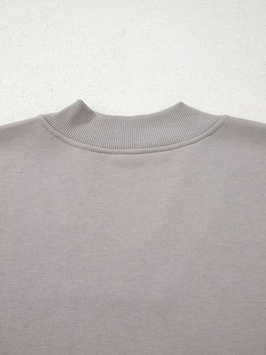 Gray sweatshirt with ribbed mock neck detail and embroidered Aztec pattern.