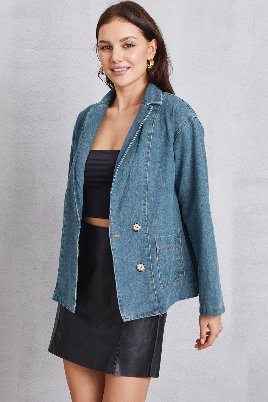Denim blazer in medium wash cotton with tailored seam detailing and button closure.
