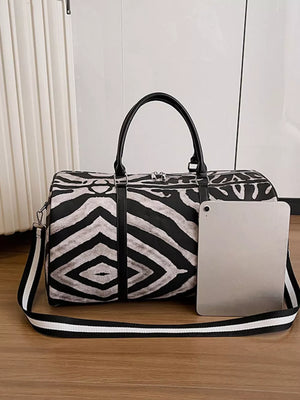 Bold zebra print duffle bag with black carry handles and detachable strap.