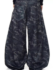 Men's baggy jeans in dark camouflage print with white stitching and back pockets.