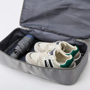 Gray dual-compartment travel tote with shoes and umbrella inside
