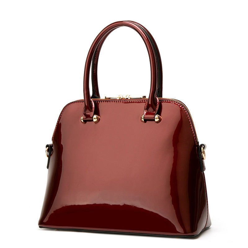 handbag in burgundy featuring patent finish and structured fit