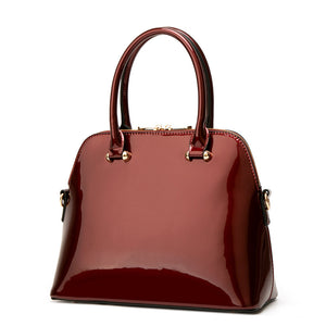 handbag in burgundy featuring patent finish and structured fit