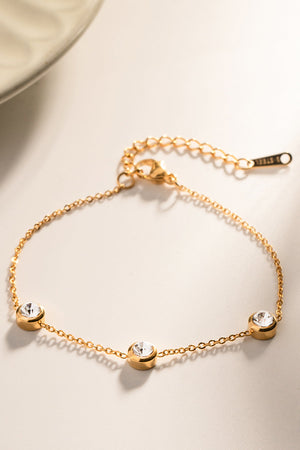 Gold chain bracelet with three clear cubic zirconia stones.