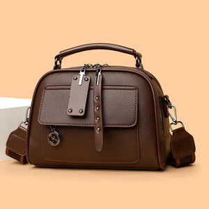 Chic structured brown crossbody bag with adjustable strap and front pocket detail.