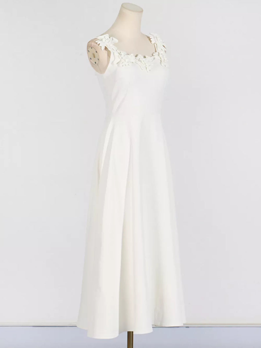 White sleeveless maxi dress with floral applique neckline and A-line skirt.