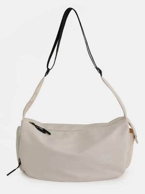 Slouchy beige crossbody bag with adjustable strap and zipper pocket
