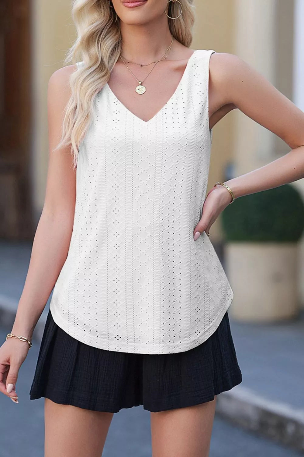White eyelet knit V neck tank top with a textured pattern.