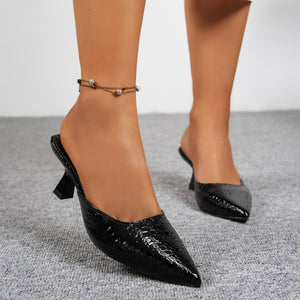 Black croc-embossed pointed toe flare heel mules with an anklet.