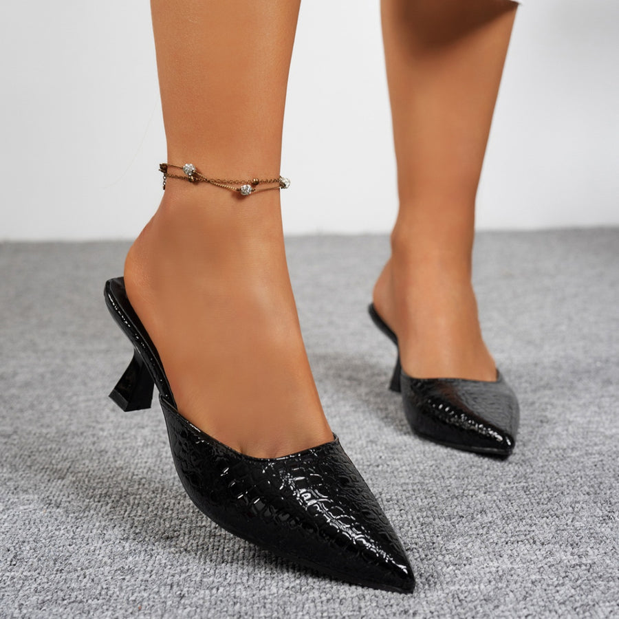 Black croc-embossed pointed toe flare heel mules with an anklet.