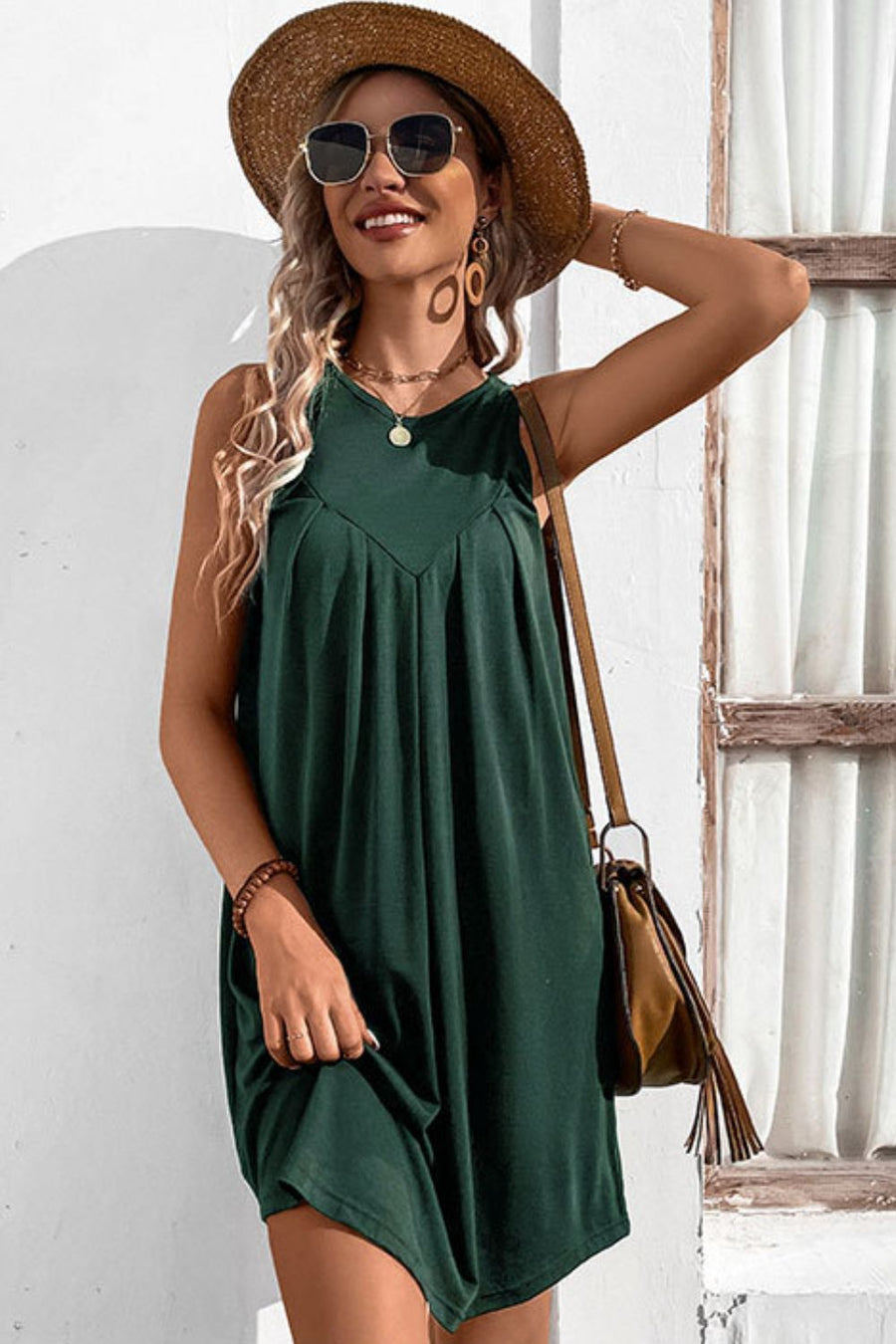 Forest green trapeze dress with V-neck yoke and pleats, sleeveless, casual style