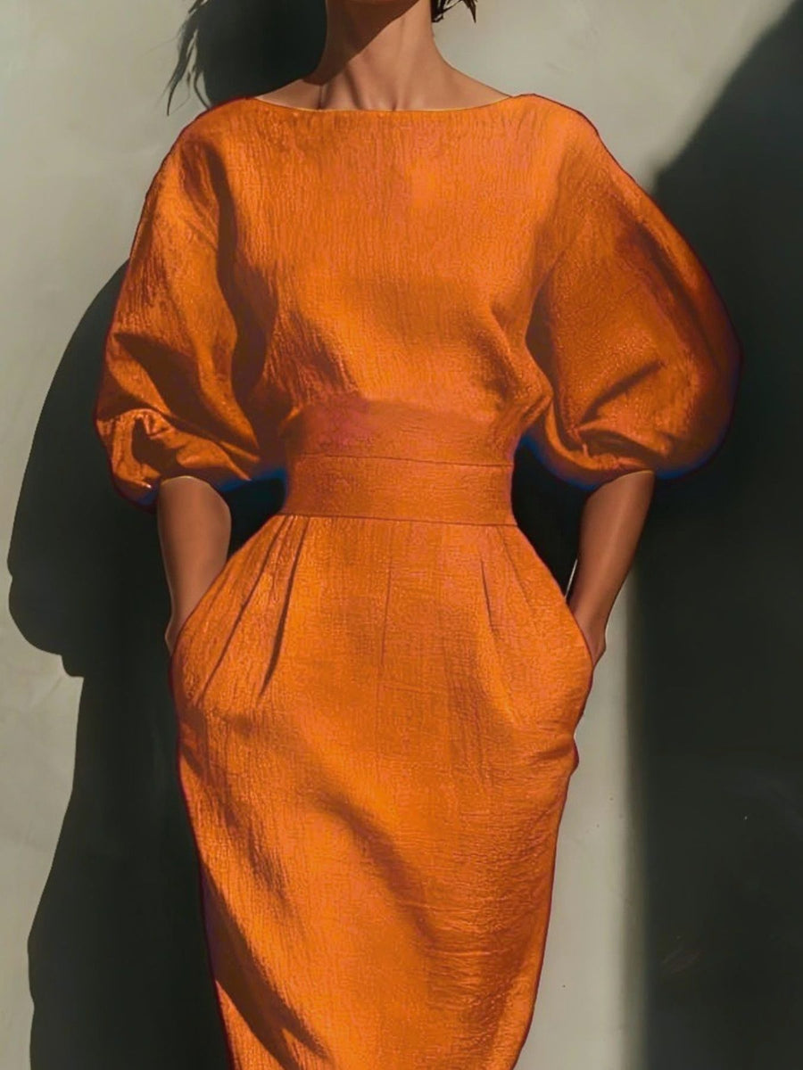 Orange midi dress with puff sleeves, boat neck, belted waist, and pockets.