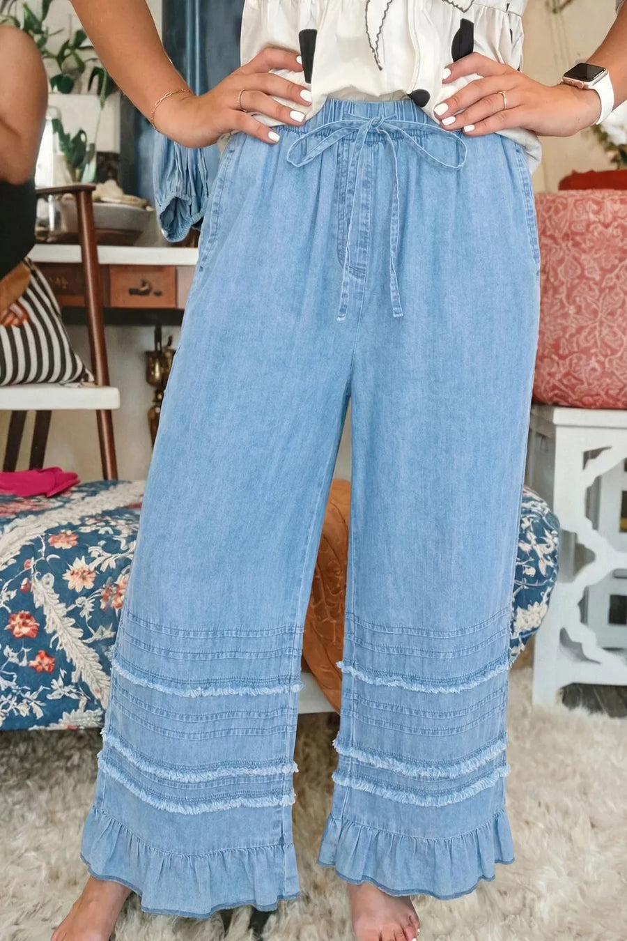 Light wash denim wide leg pants with tiered ruffle hem and drawstring waist