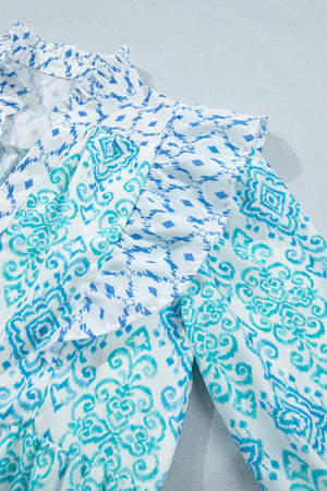 Blue and white patchwork ruffle mini dress with ornate print and ruffled neckline.
