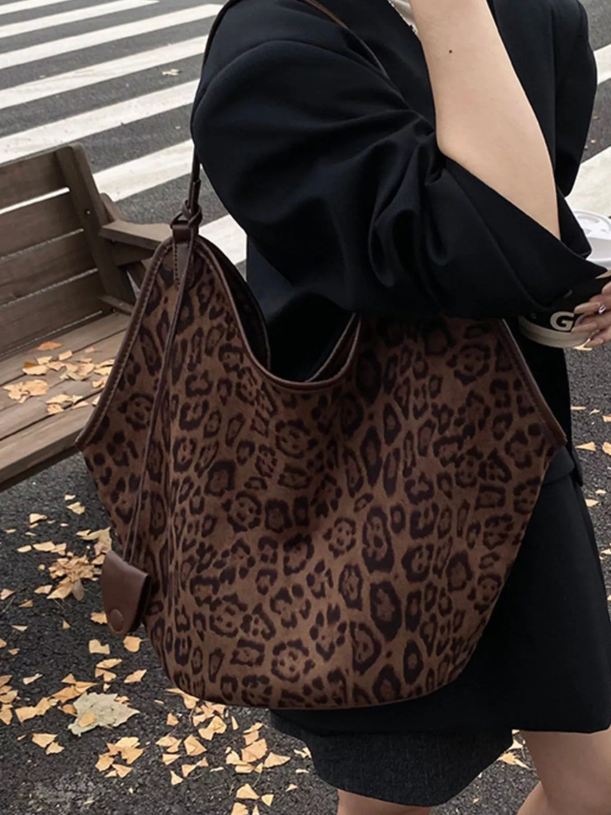 Brown leopard print tote bag with leather trim and a small flap pocket detail.
