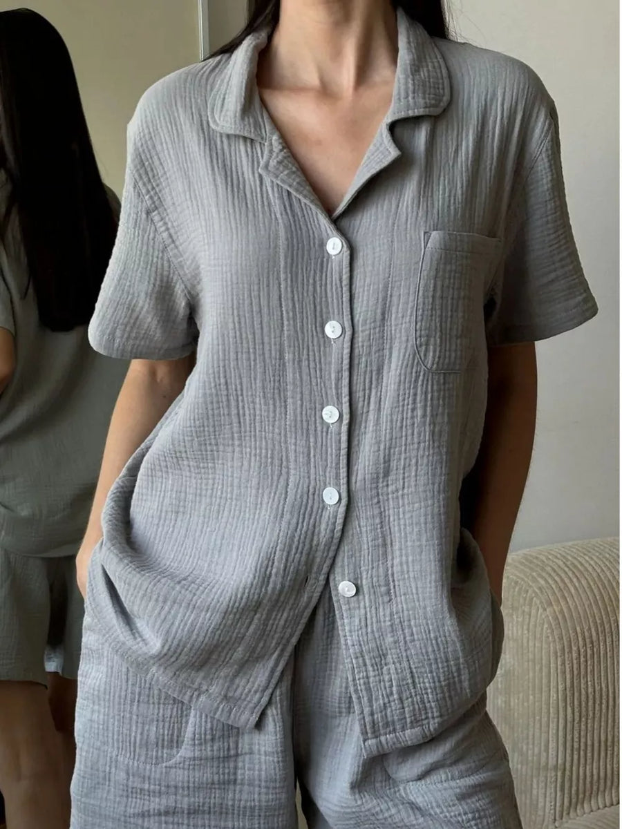 Gray cotton button-up pajama set with collared short-sleeve shirt and shorts.