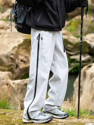 Men's white wide-leg sweatpants with black zipper details and pockets.