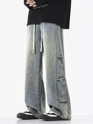 Oversized vintage wash wide leg jeans in light blue with distressed details and drawstring waist.