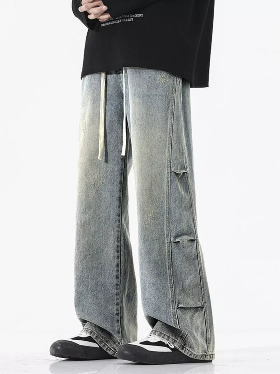 Oversized vintage wash wide leg jeans in light blue with distressed details and drawstring waist.