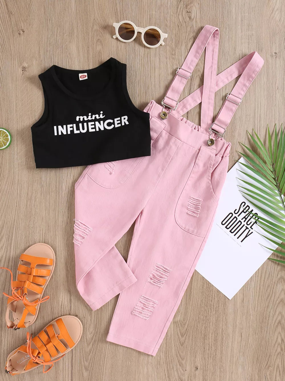 Black graphic tank top with white text and pink distressed denim overalls set