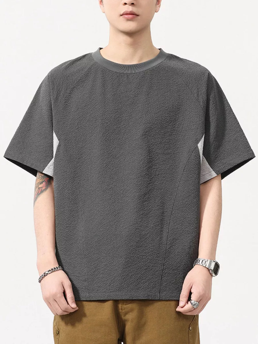 Men's dark gray textured t-shirt with contrast panels and crew neck.