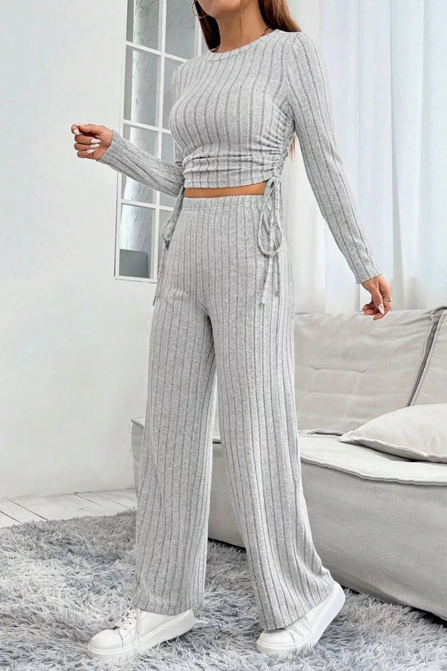 Light gray ribbed knit long sleeve crop top with drawstring sides and matching wide-leg pants.