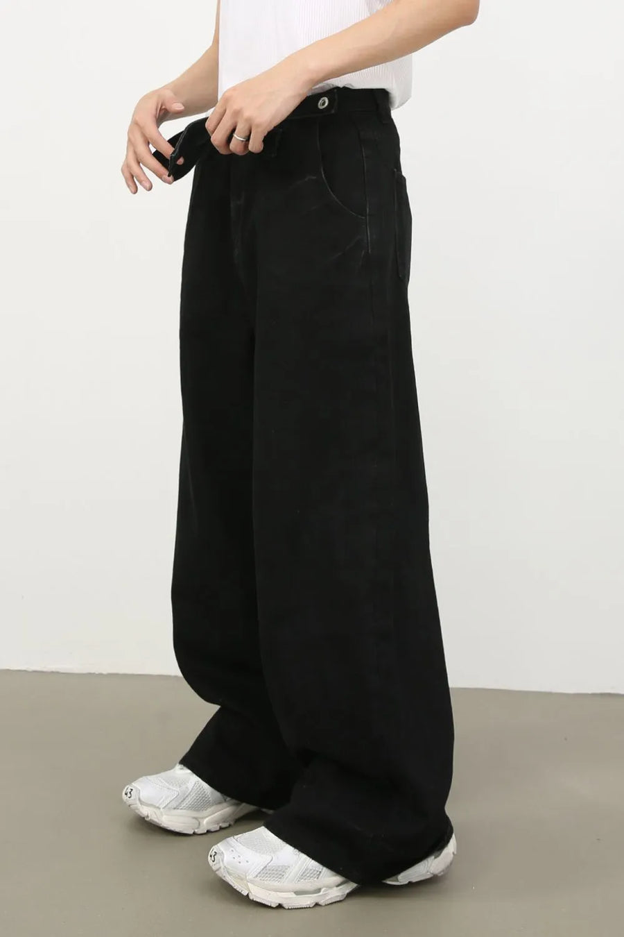 Black denim jeans with exaggerated wide legs and a tie detail.