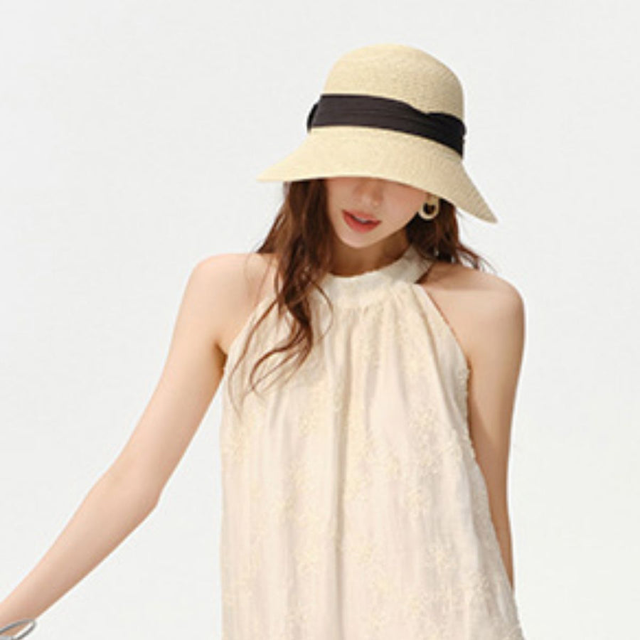 Beige woven straw wide brim sun hat with black ribbon detail.