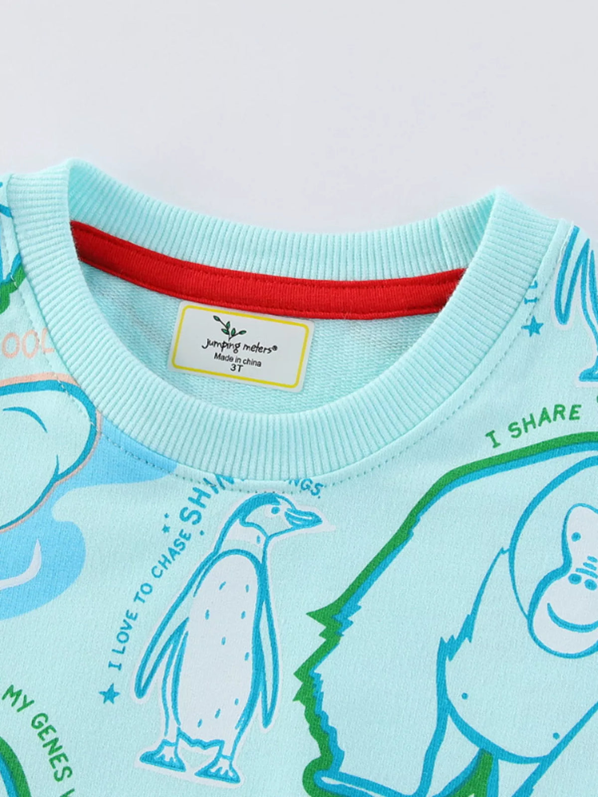 Mint blue cotton blend sweatshirt with playful animal print and red neckline trim.