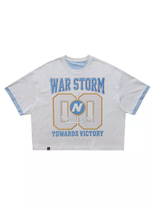 Graphic tee with text "WAR STORM" and "TOWARDS VICTORY" in blue and gold on heather grey cotton.