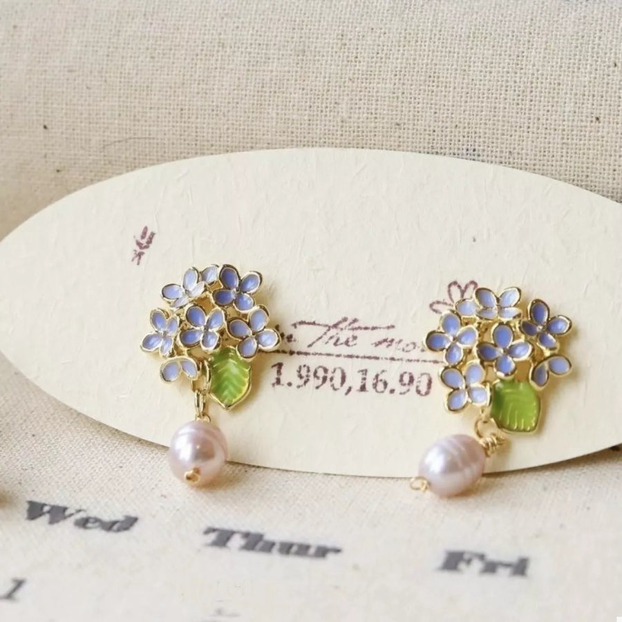 Floral pearl drop earrings in light blue with gold accents and pink pearls.