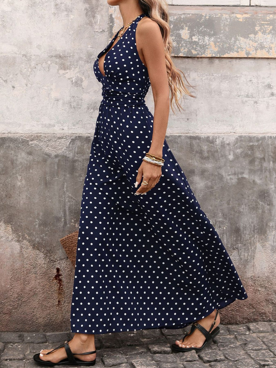 Navy polka dot maxi dress with halter neck and cinched waist.