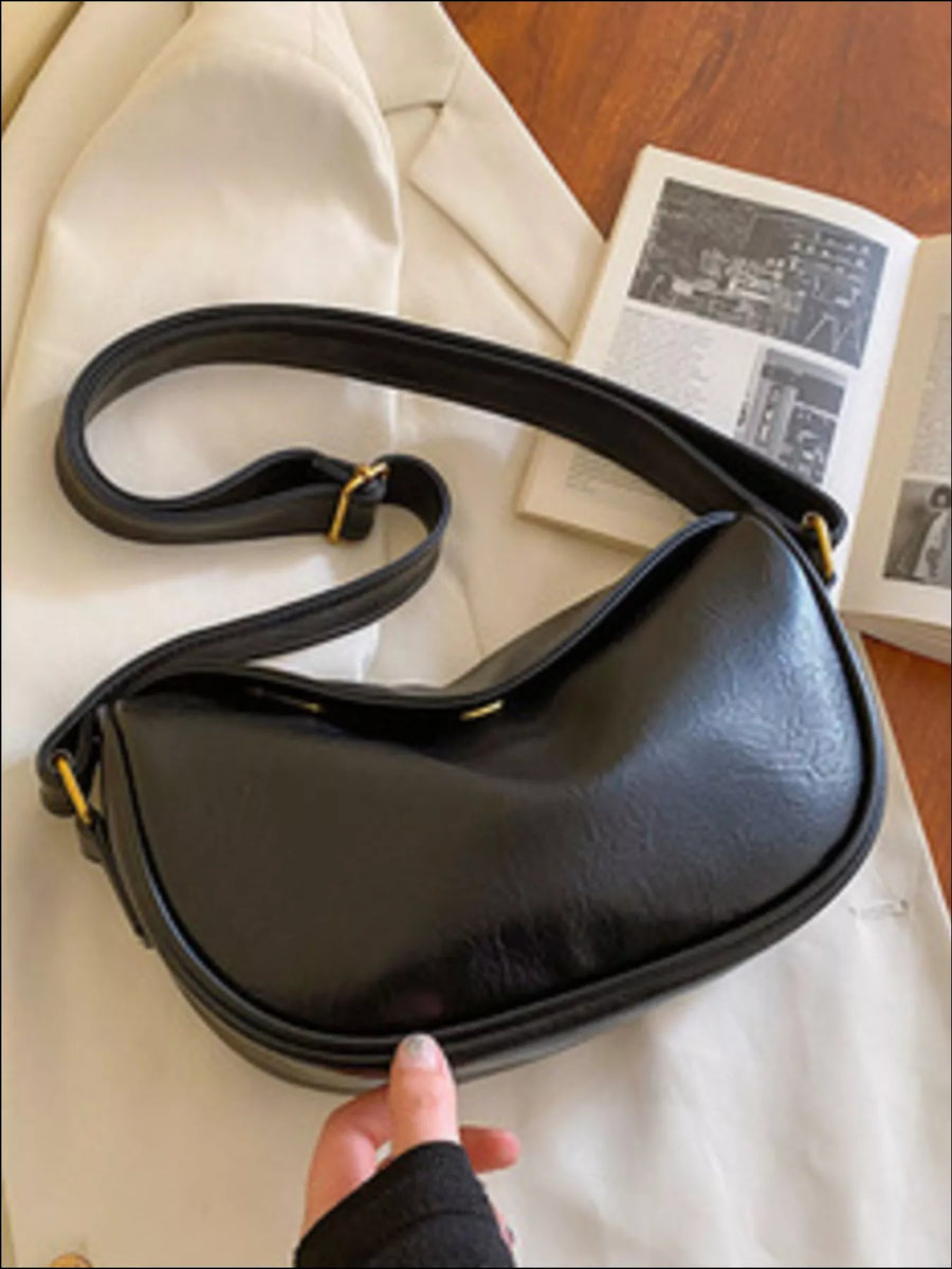 Black leather crossbody bag with adjustable strap and gold hardware detail