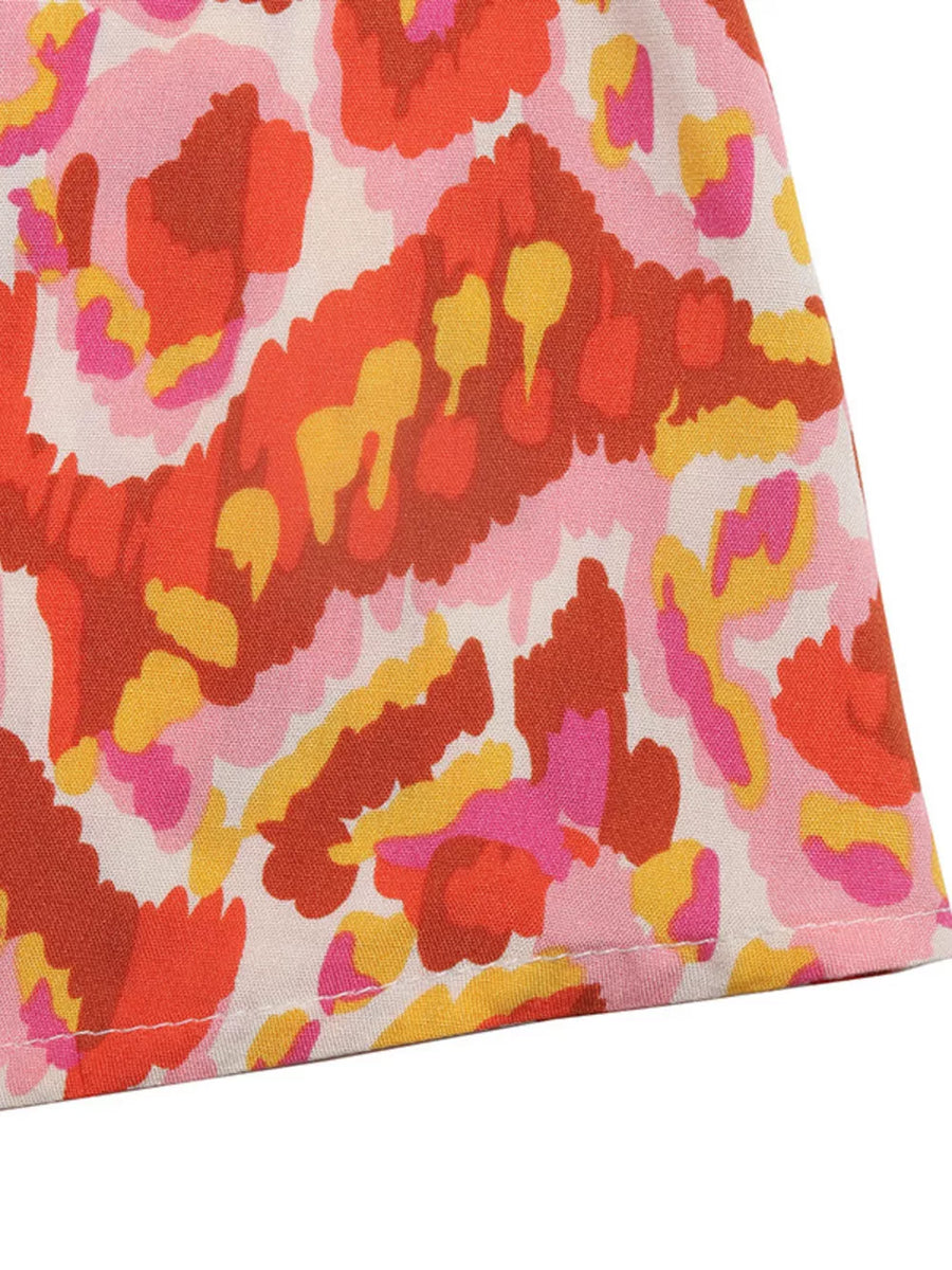 Abstract print maxi dress in pink, red, orange, and yellow.