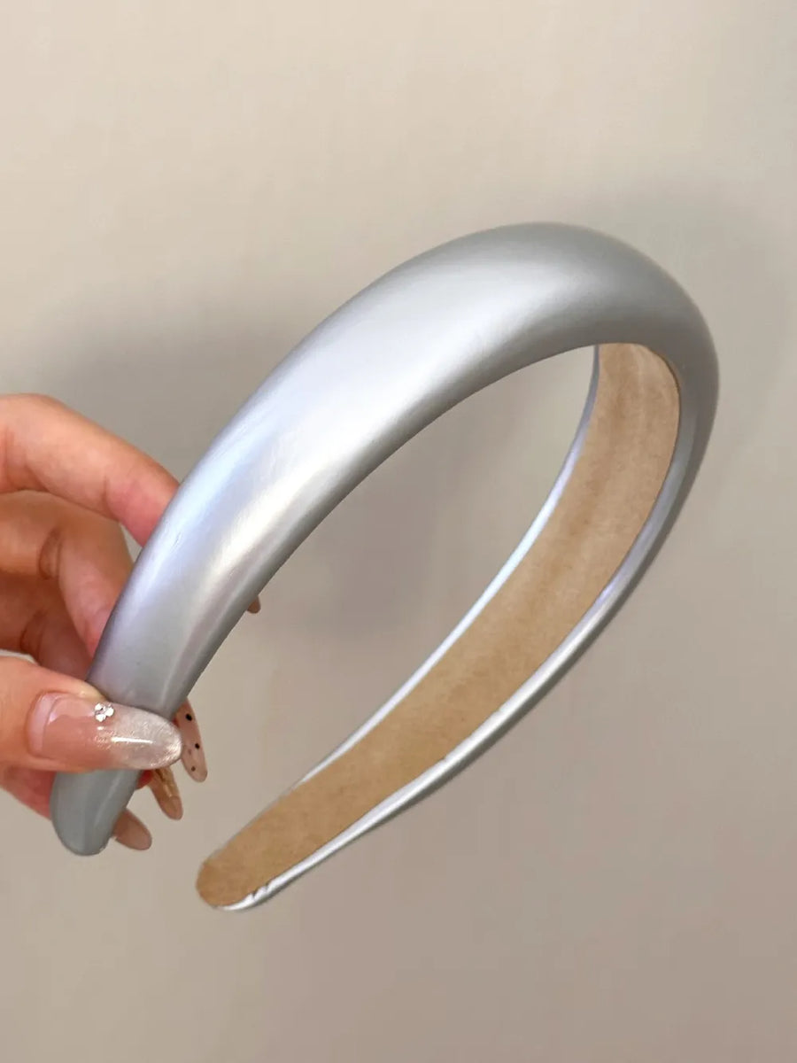 Glossy padded headband in silver with a smooth finish.