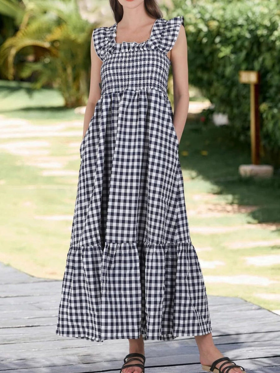 Black gingham midi dress with square neck, smocked bodice, ruffled sleeves, tiered skirt, and pockets.