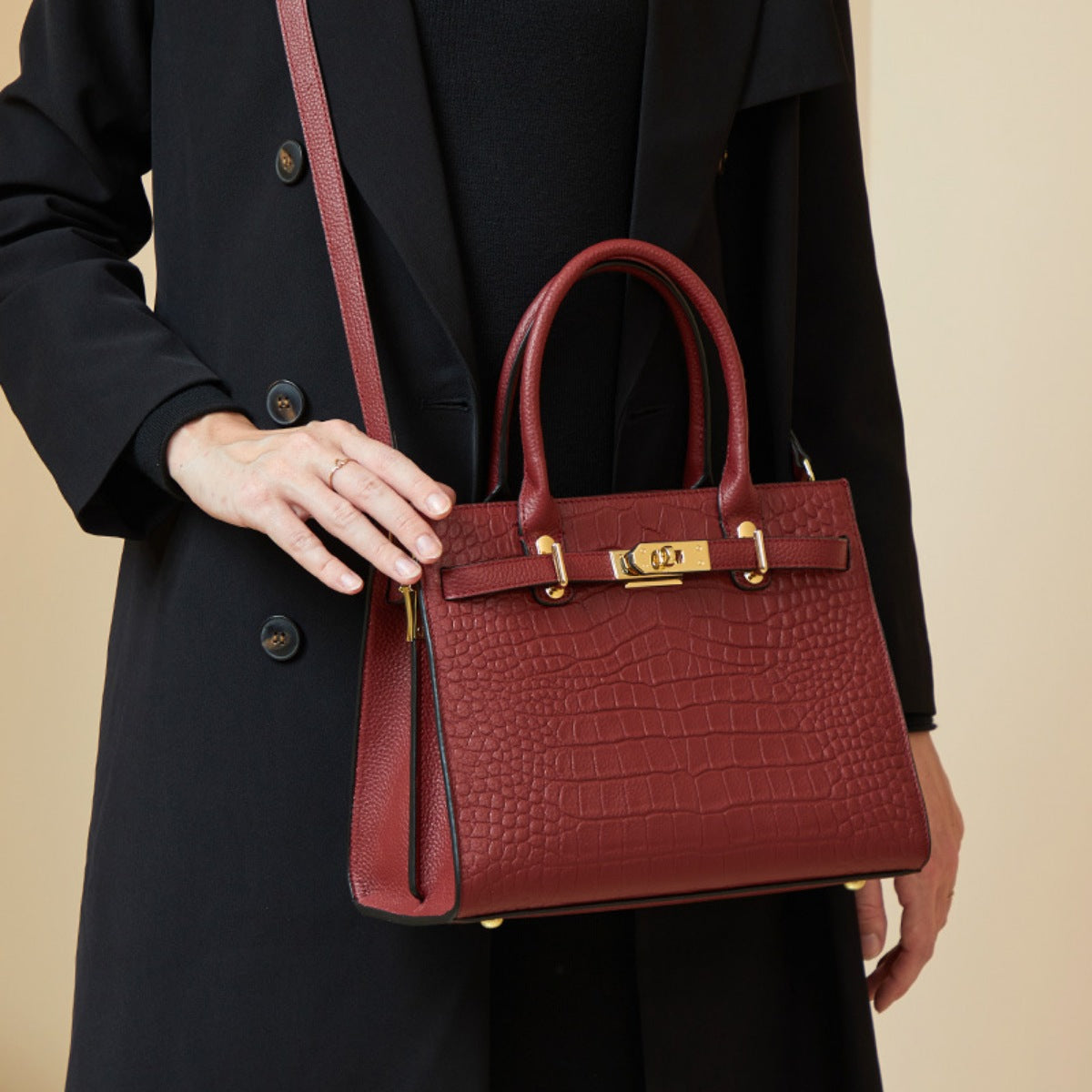 Burgundy crocodile-embossed medium tote handbag with gold hardware and top handles.