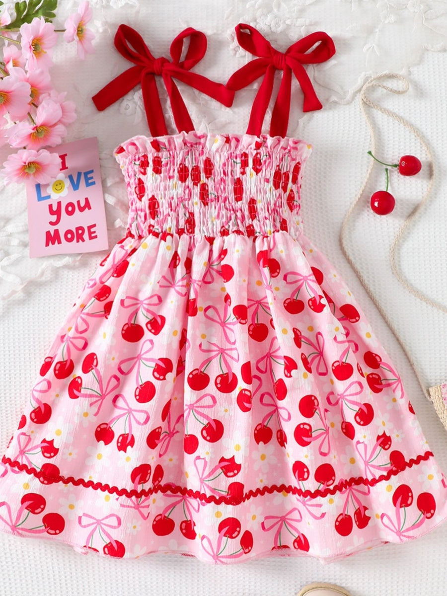 Pink cherry print smocked toddler dress with red bow straps and ruffled hem.
