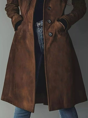 Brown long-sleeve trench coat with button closure and pockets, styled with jeans.