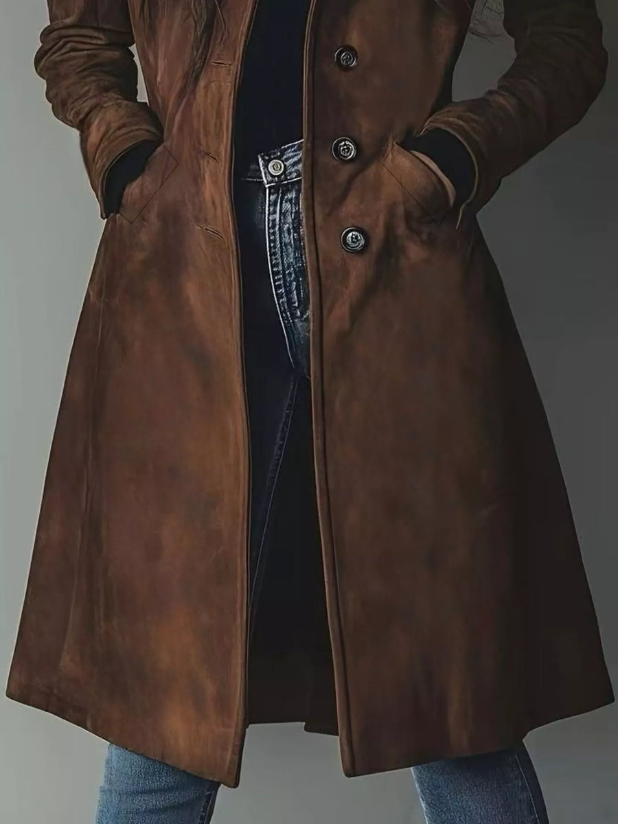 Brown long-sleeve trench coat with button closure and pockets, styled with jeans.