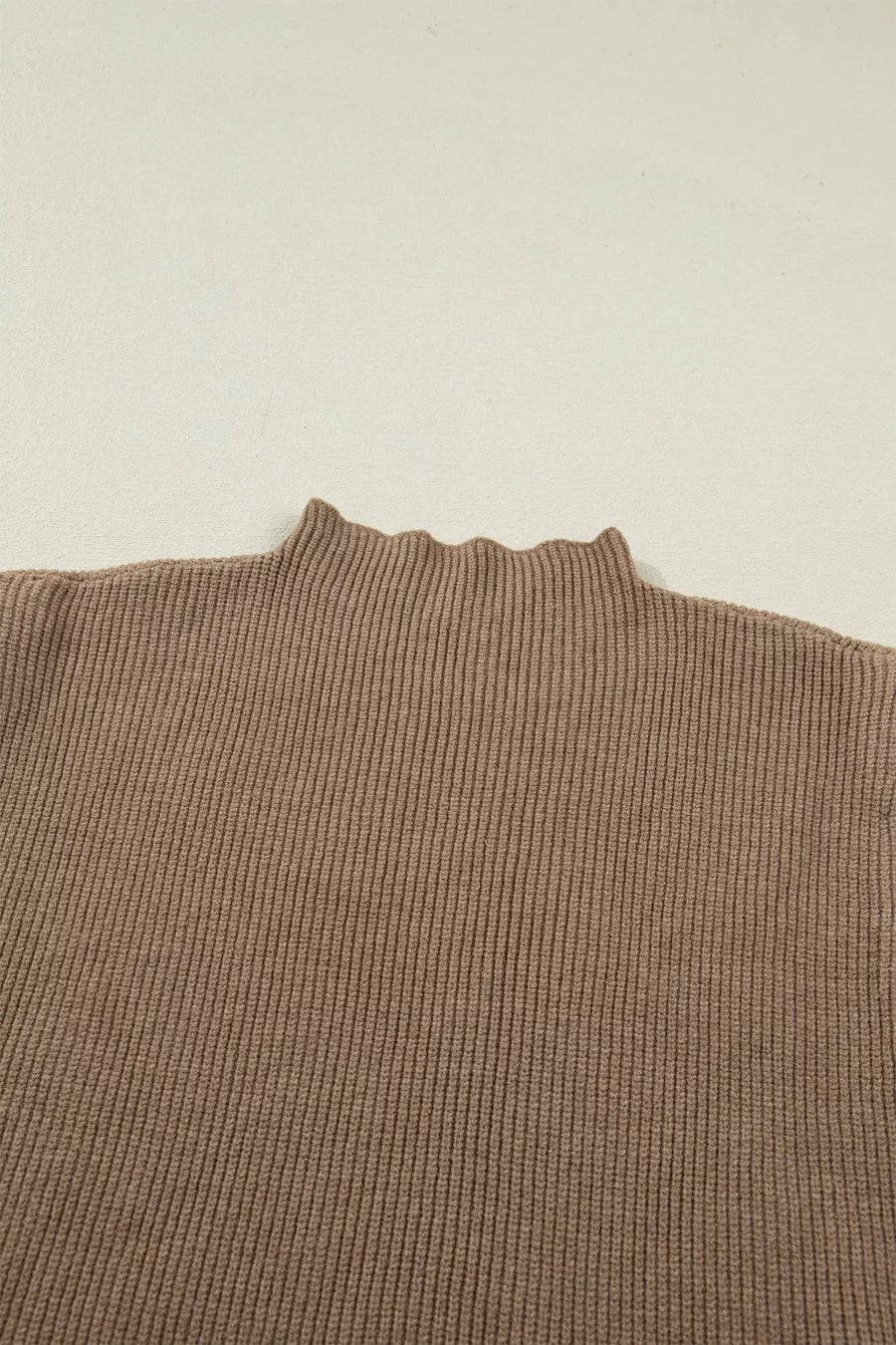 Brown ribbed knit mock neck sweater vest with lettuce edge detail.