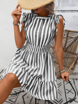 Striped summer dress with tied shoulders, button front, smocked waist, and ruffled hem.