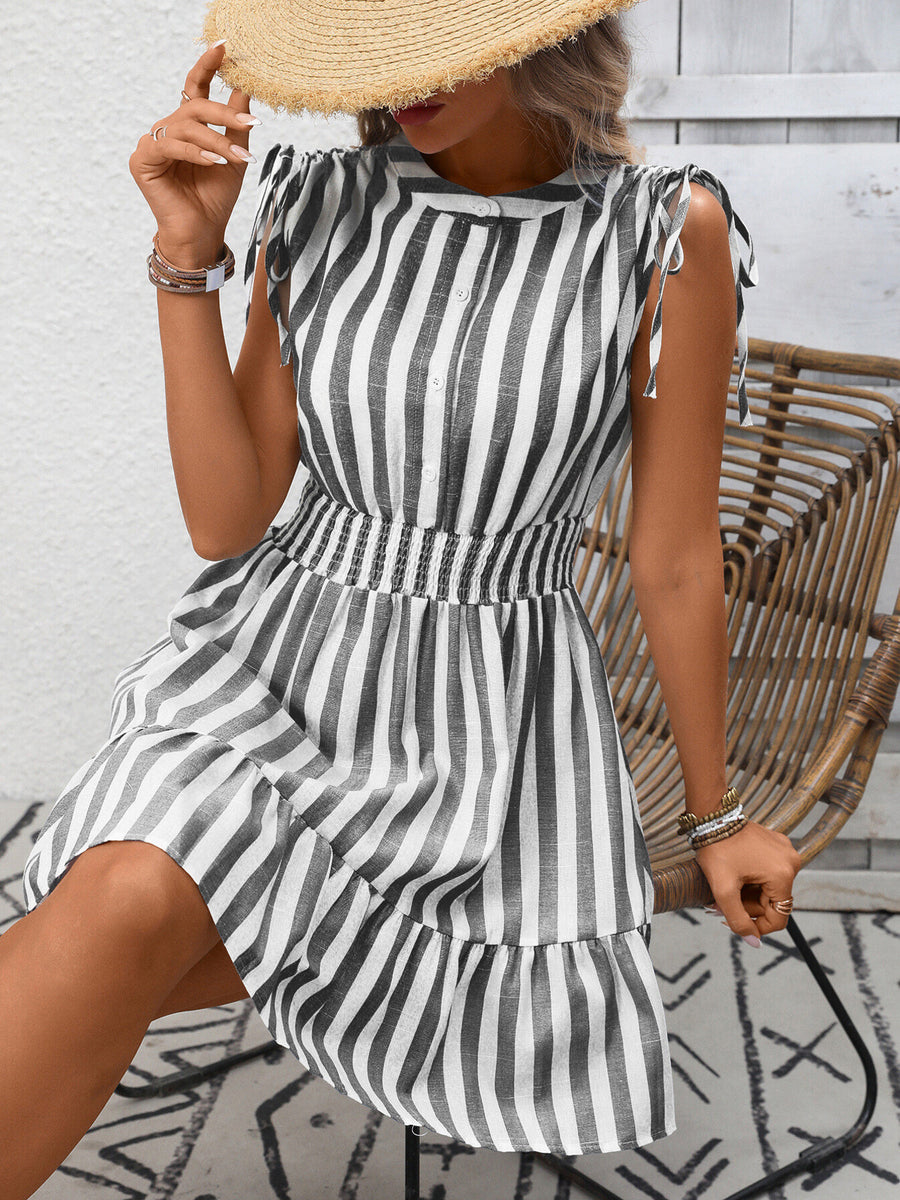 Striped summer dress with tied shoulders, button front, smocked waist, and ruffled hem.