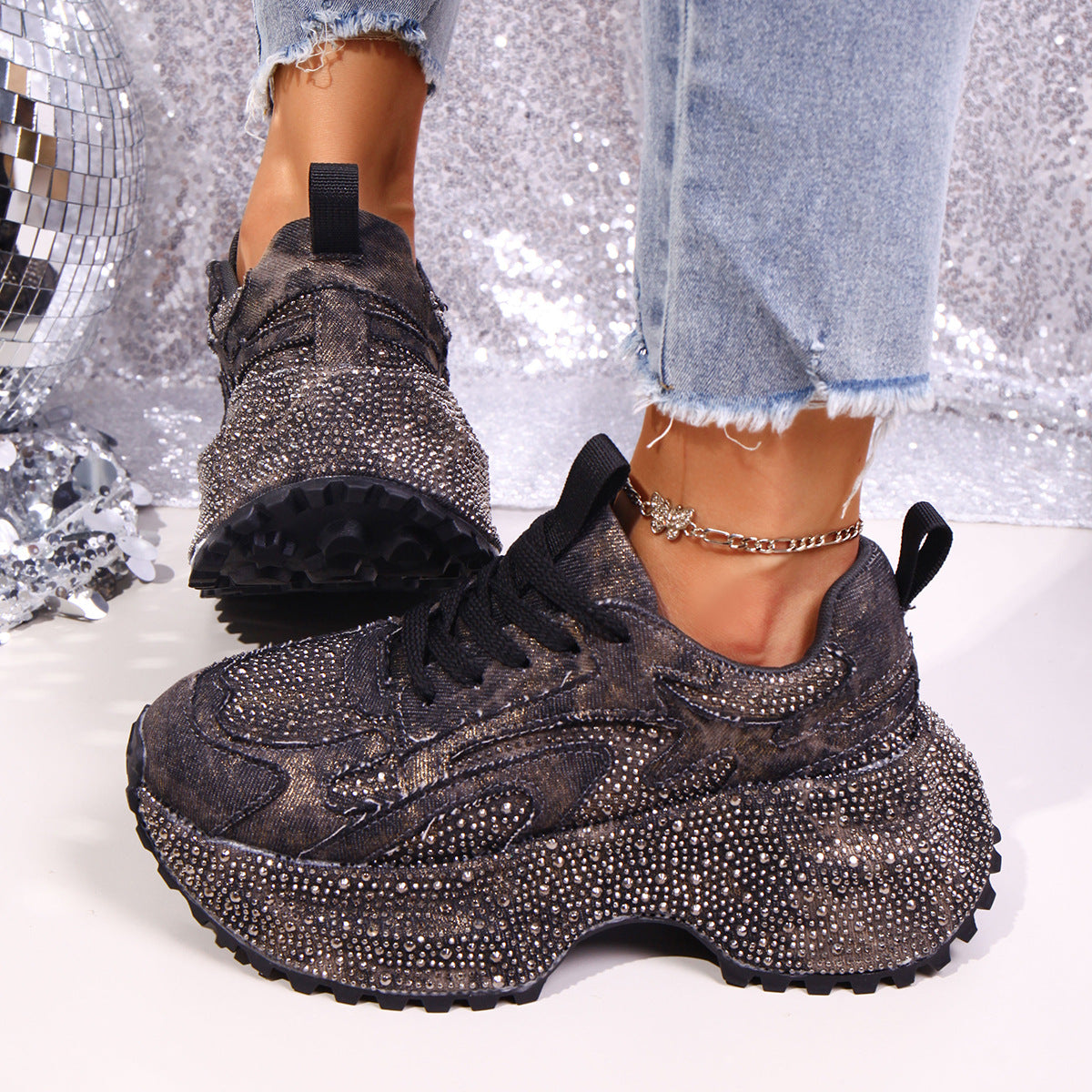 Black rhinestone platform sneakers with chunky sole and lace-up closure.