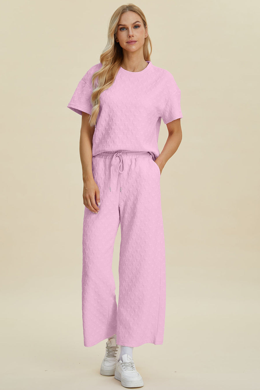 Pink textured knit lounge set with wide leg pants and a short sleeve top.