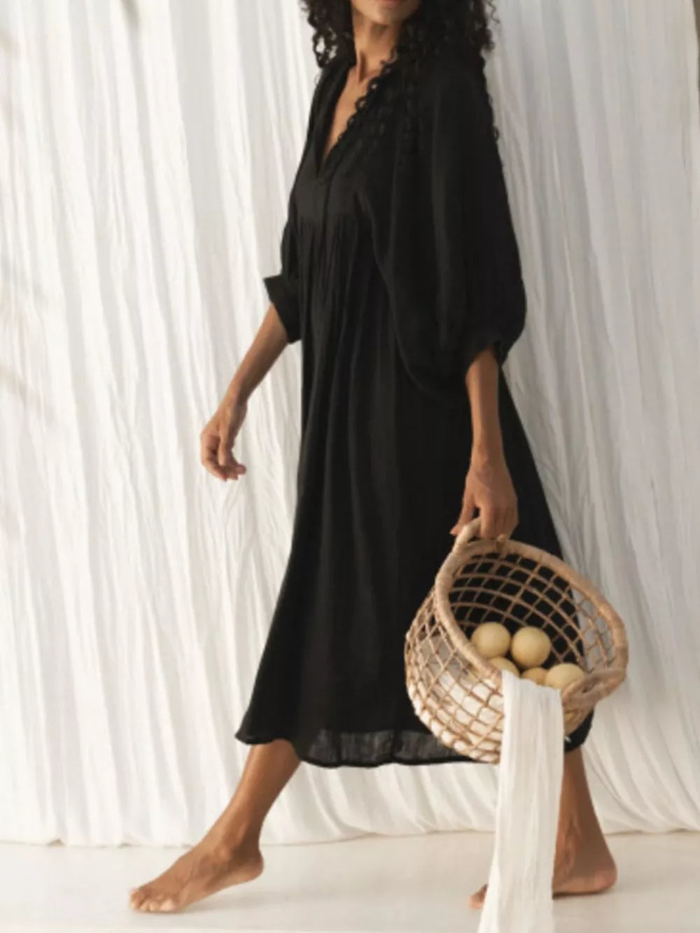 Black tie-neck midi dress with puff sleeves and lace detail.